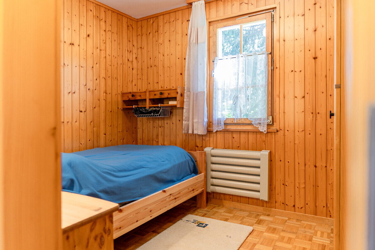 Kleines Schlafzimmer mit Holzverkleidung