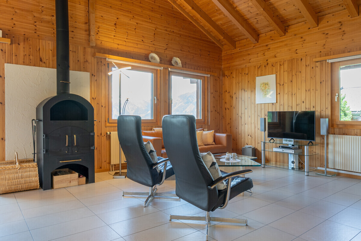 Gemütliches Holz-Wohnzimmer mit Kamin und Bergblick