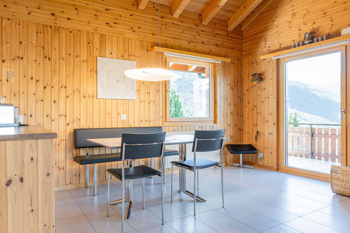 Heller Essbereich mit Holzverkleidung und Bergblick