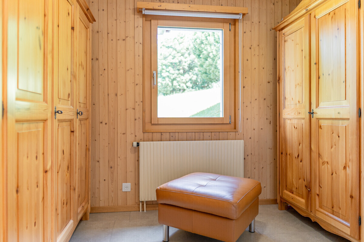 Holzvertäfelter Raum mit Fenster und Hocker