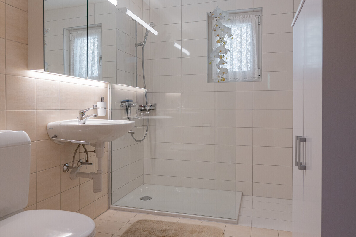 Helles Badezimmer mit Dusche und Fenster
