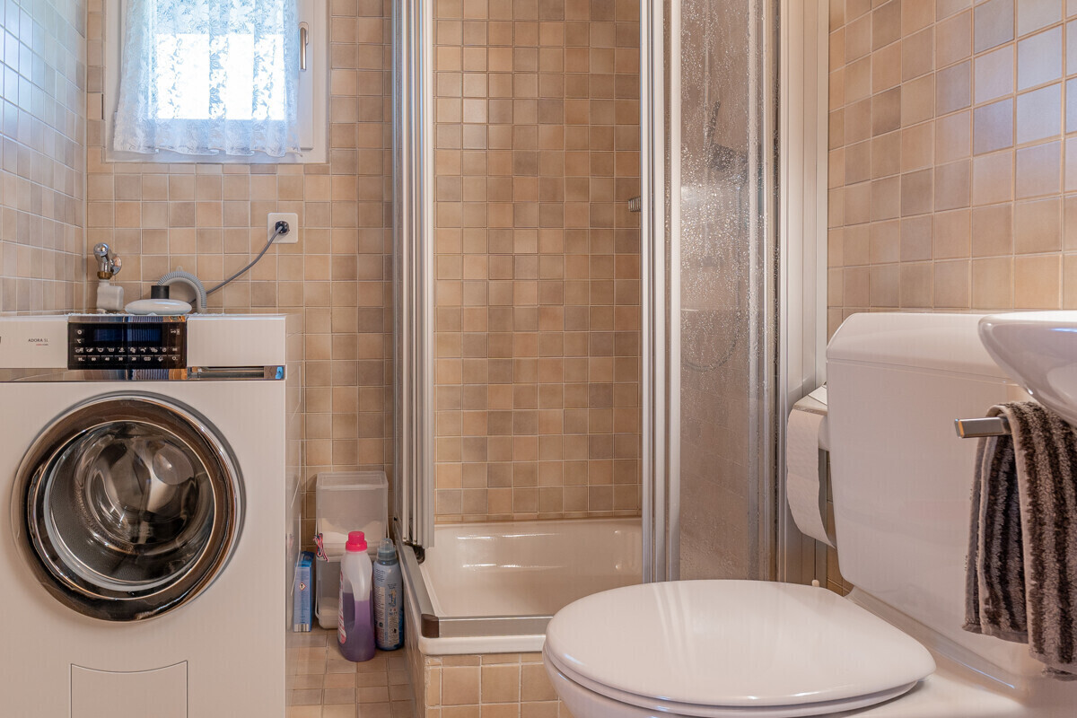Badezimmer mit Waschmaschine und Dusche