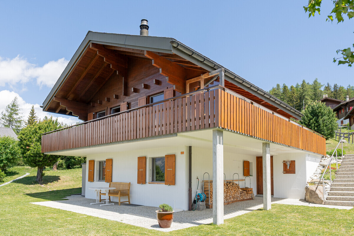 Außenansicht eines alpinen Holzhauses mit großer Terrasse
