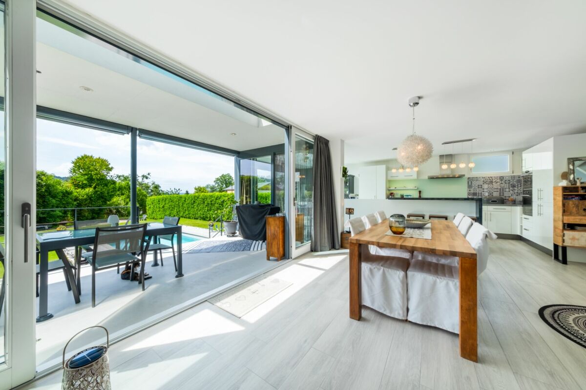 Offener Wohn-Essbereich mit Terrasse und Poolblick
