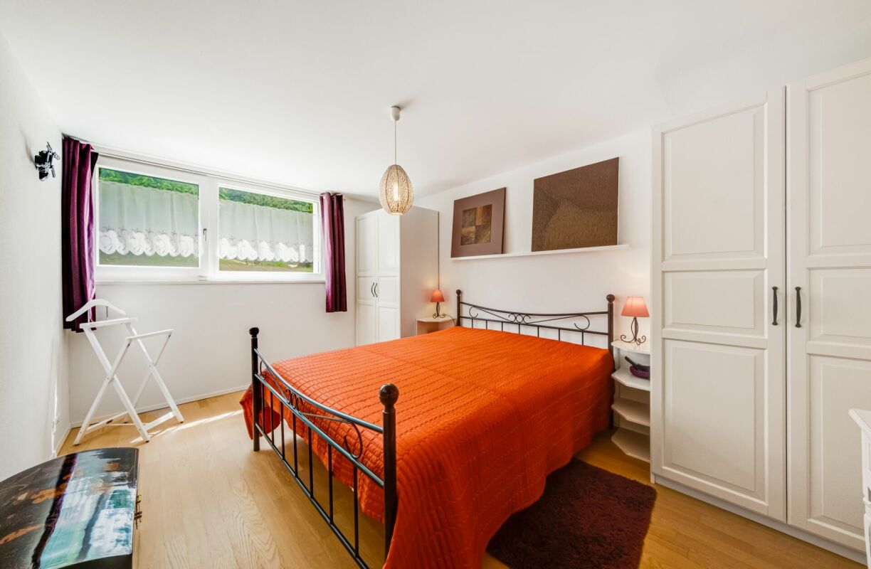 Helles Schlafzimmer mit Metallbett und Einbauschrank