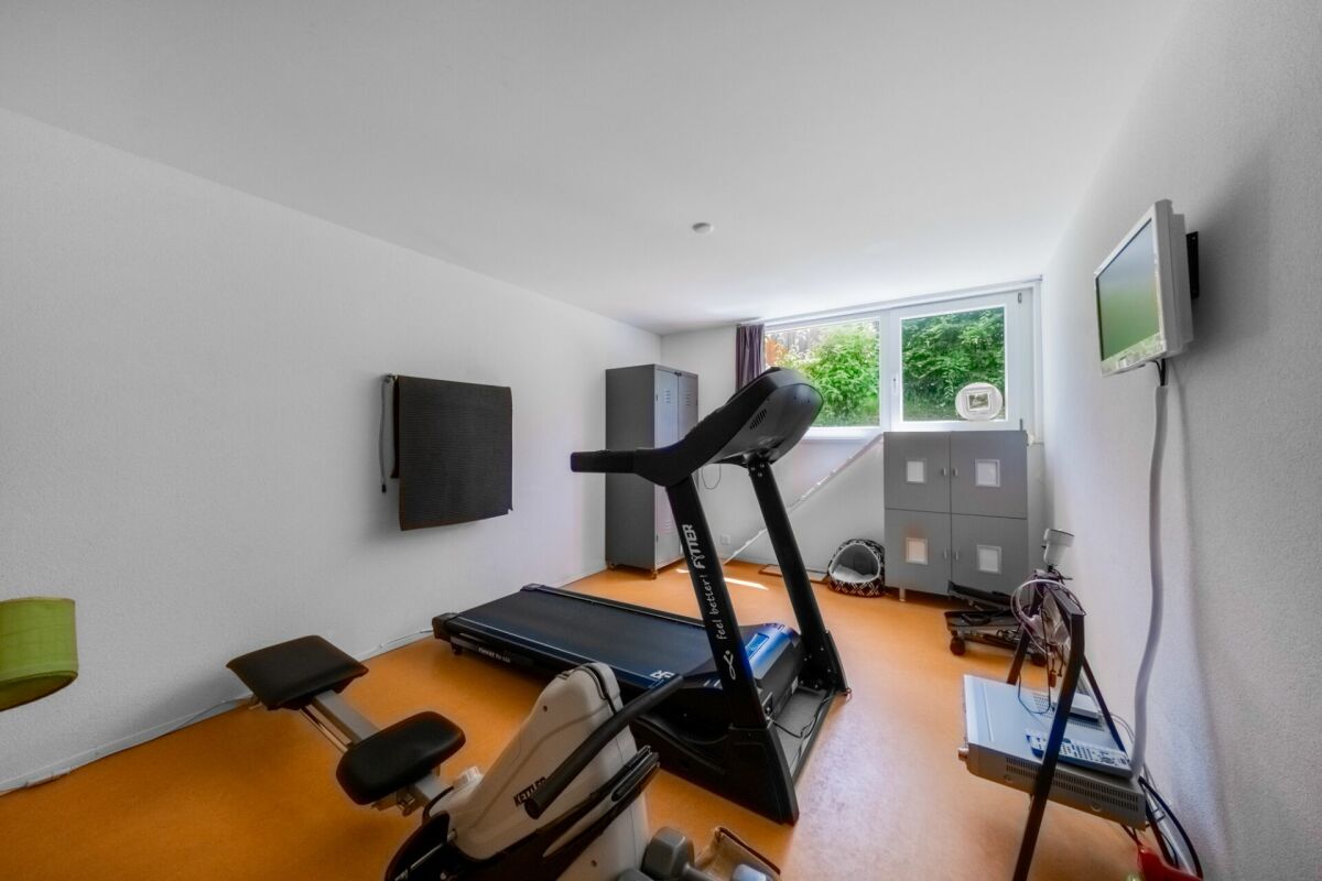 Fitnessraum mit Laufband und Fenster