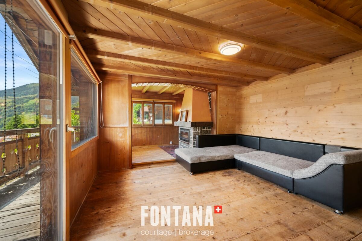 Gemütlicher Holzwohnraum mit Kamin und Balkon