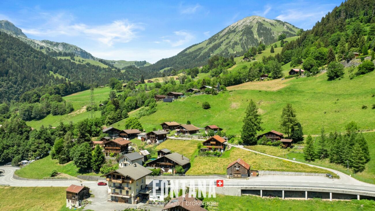 Alpine Tal- und Berglandschaft mit verstreuten Chalets