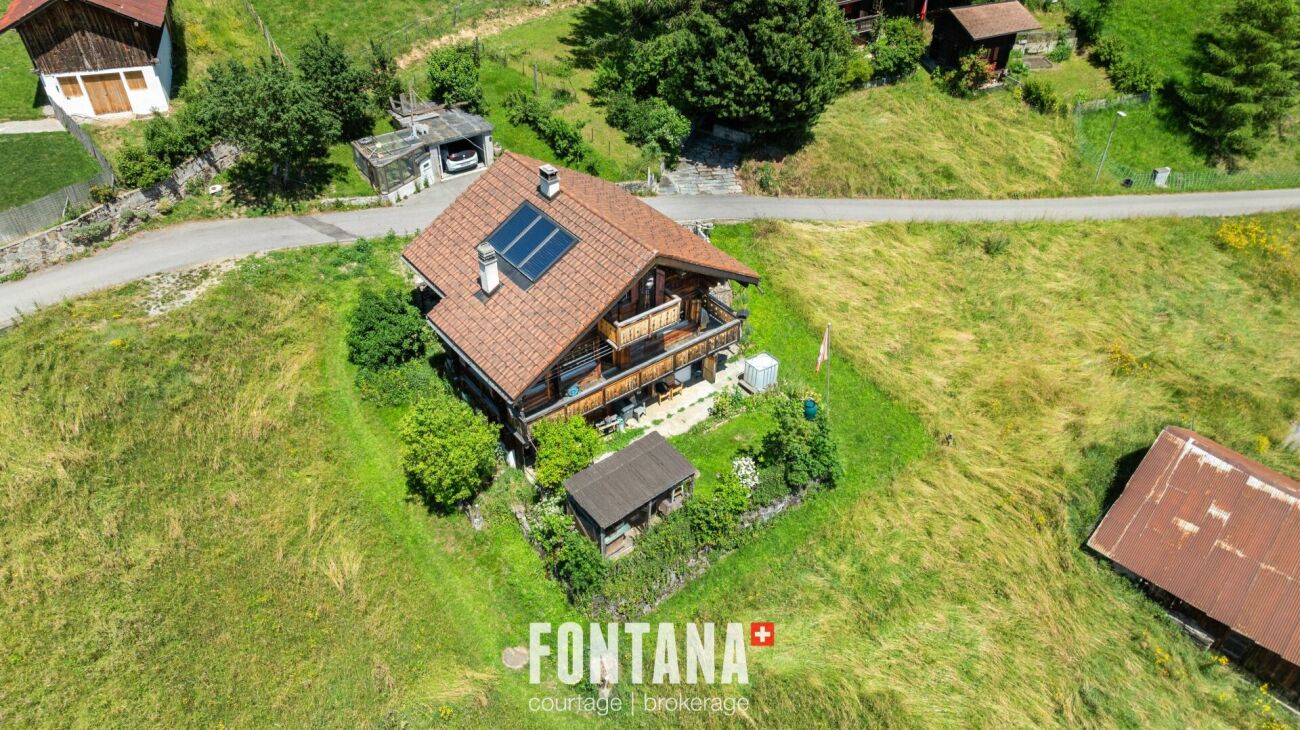Luftaufnahme eines Chalet-Hauses mit großem Grundstück