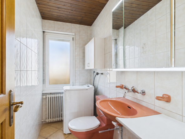 Badezimmer mit Fenster, Waschbecken und WC