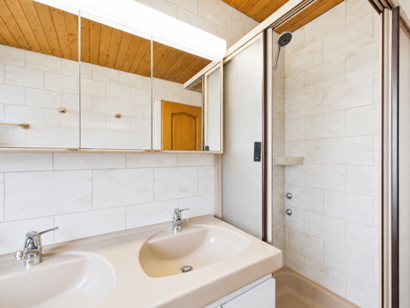 Helles Badezimmer mit Doppelwaschbecken und Dusche