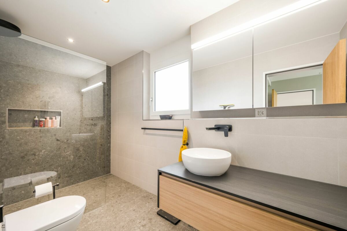 Modernes Badezimmer mit bodengleicher Dusche und Waschtisch