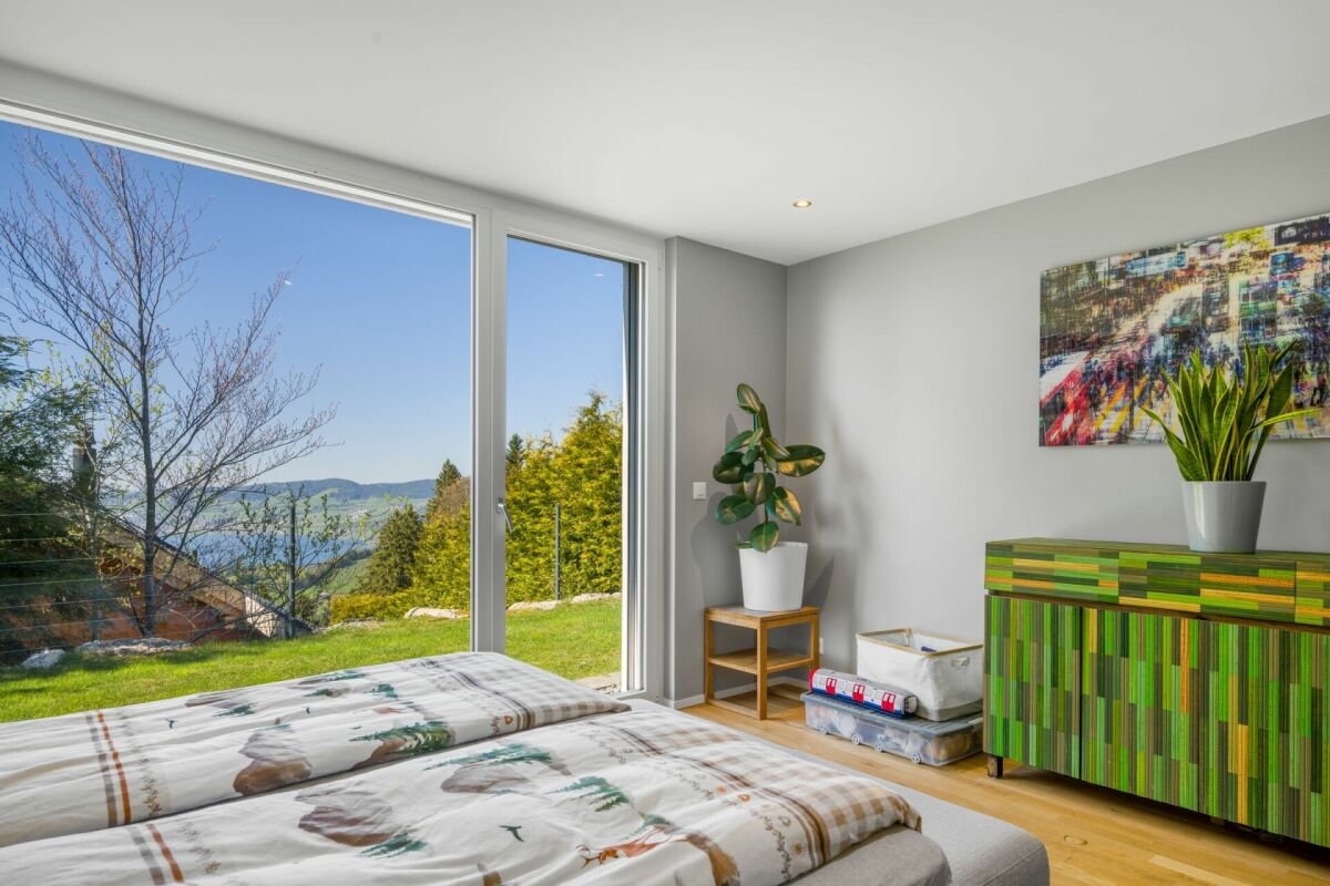 Modernes Schlafzimmer mit Panoramafenster und Bergblick