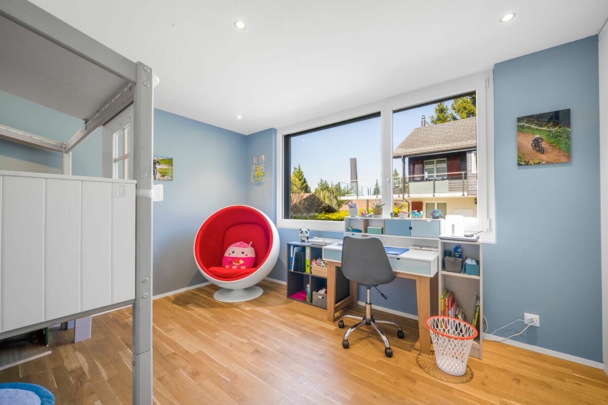 Kinderzimmer mit Schreibtisch und großem Fenster