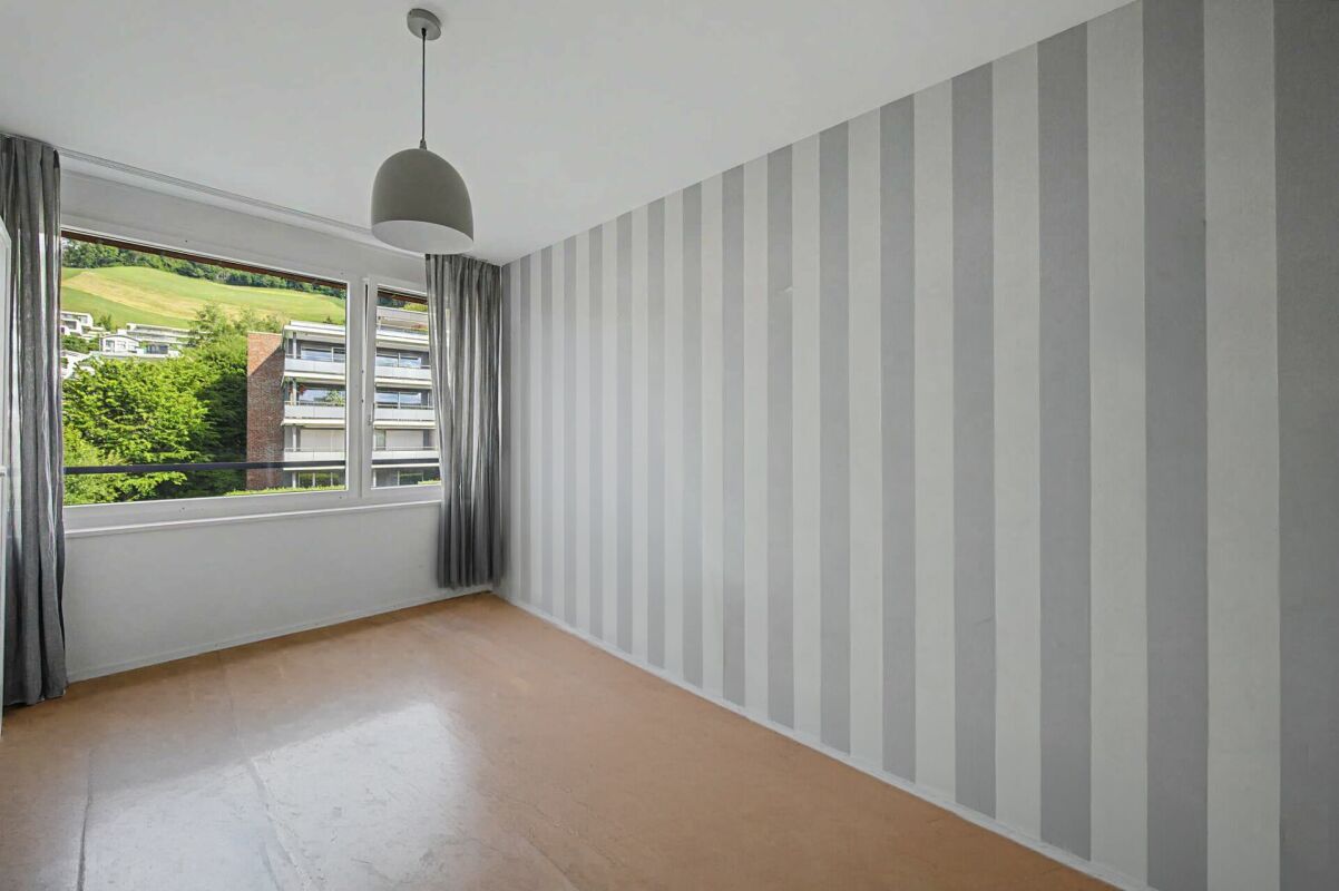 Leeres Zimmer mit Streifenwand und Fensterblick