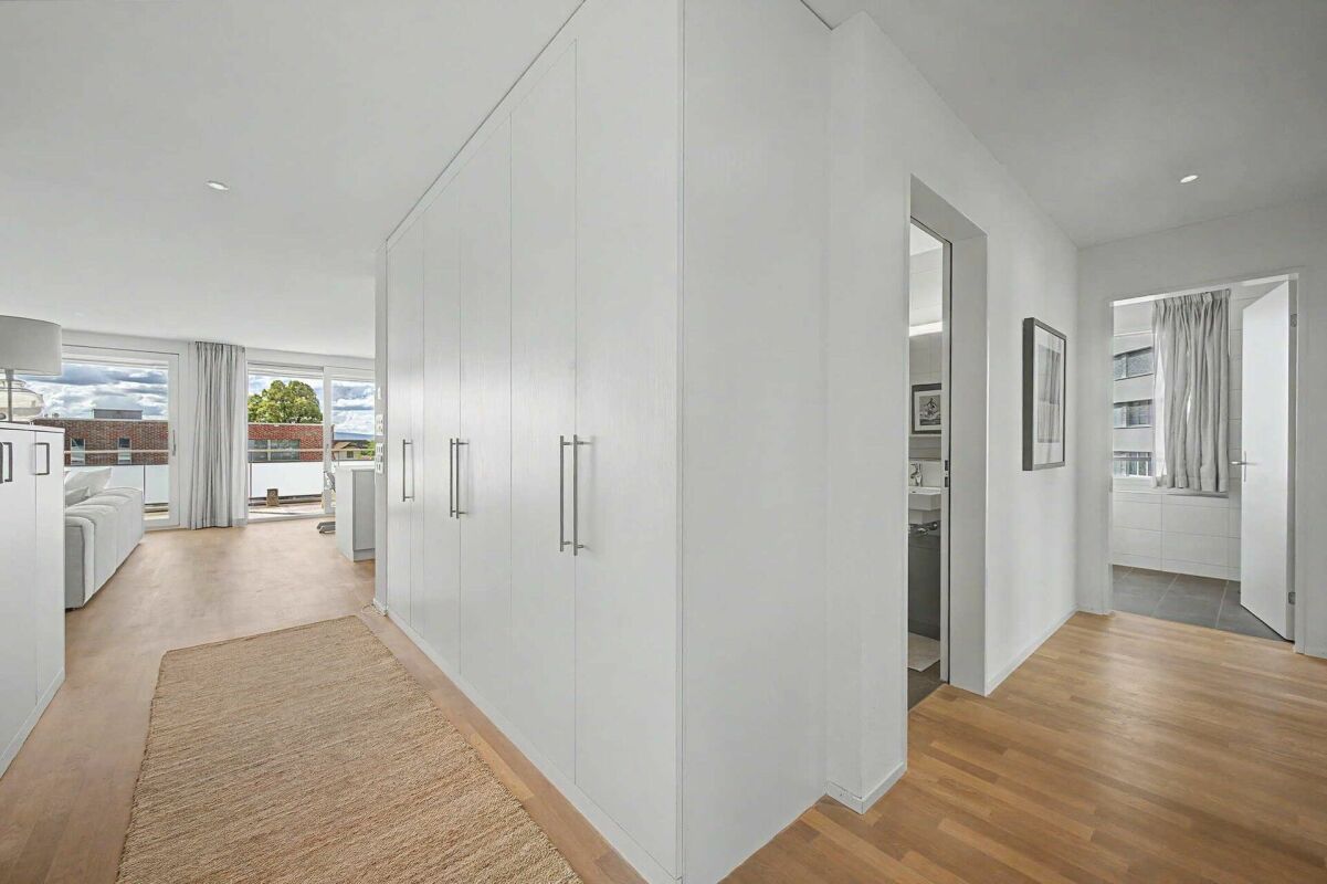 Heller Flur mit Einbauschrank und Blick ins Schlafzimmer sowie Bad
