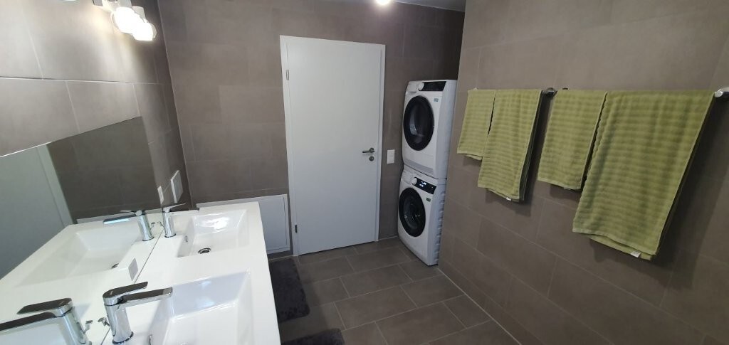 Modernes Badezimmer mit Doppelwaschbecken und Waschmaschine