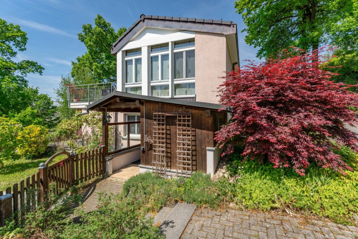 Ein freistehendes Wohnhaus mit Garten und Holzvorbau