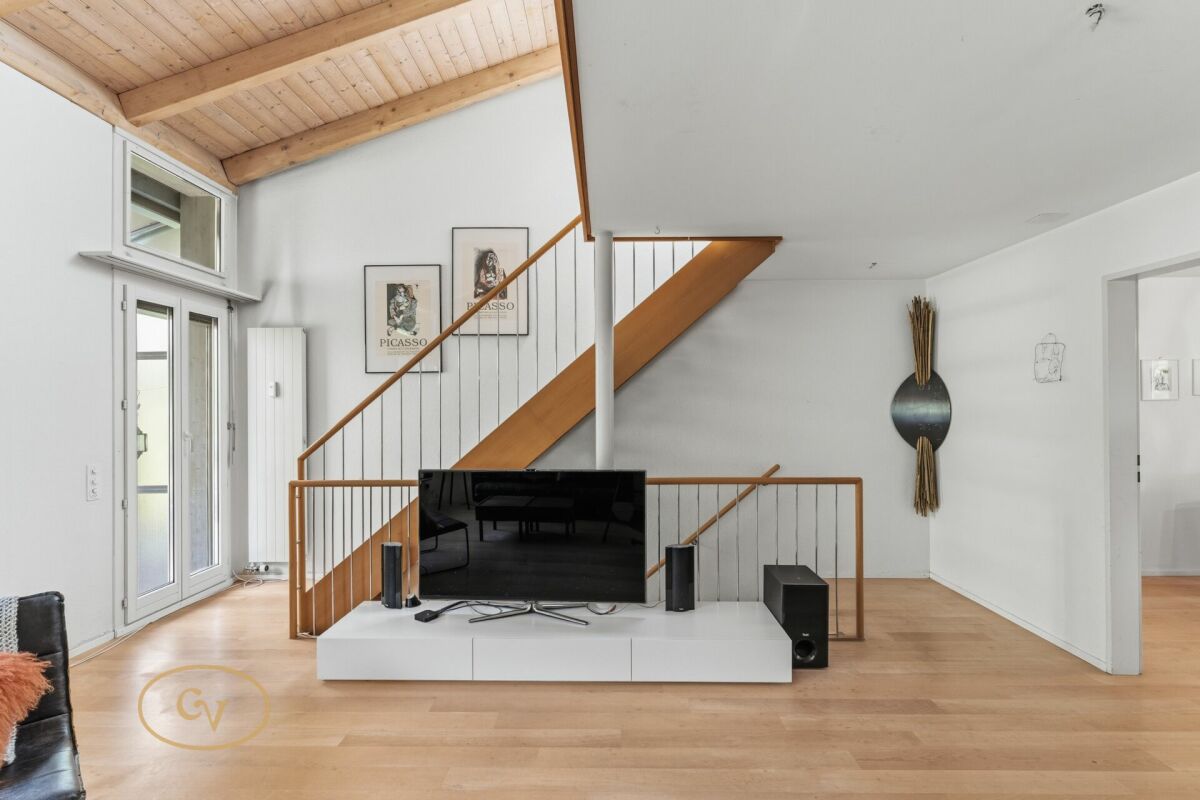 Heller Wohnraum mit Treppe und TV-Bereich