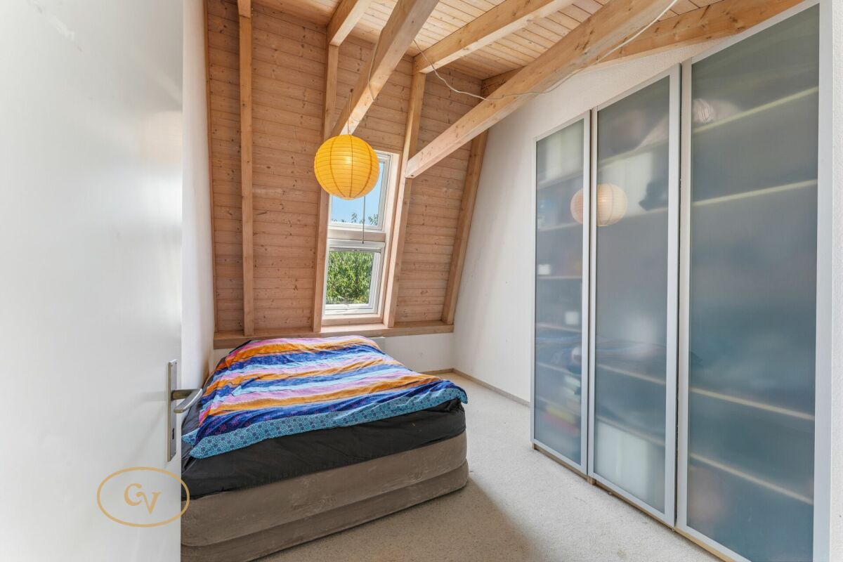 Dachgeschoss-Schlafzimmer mit Holzdecke und Einbauschrank
