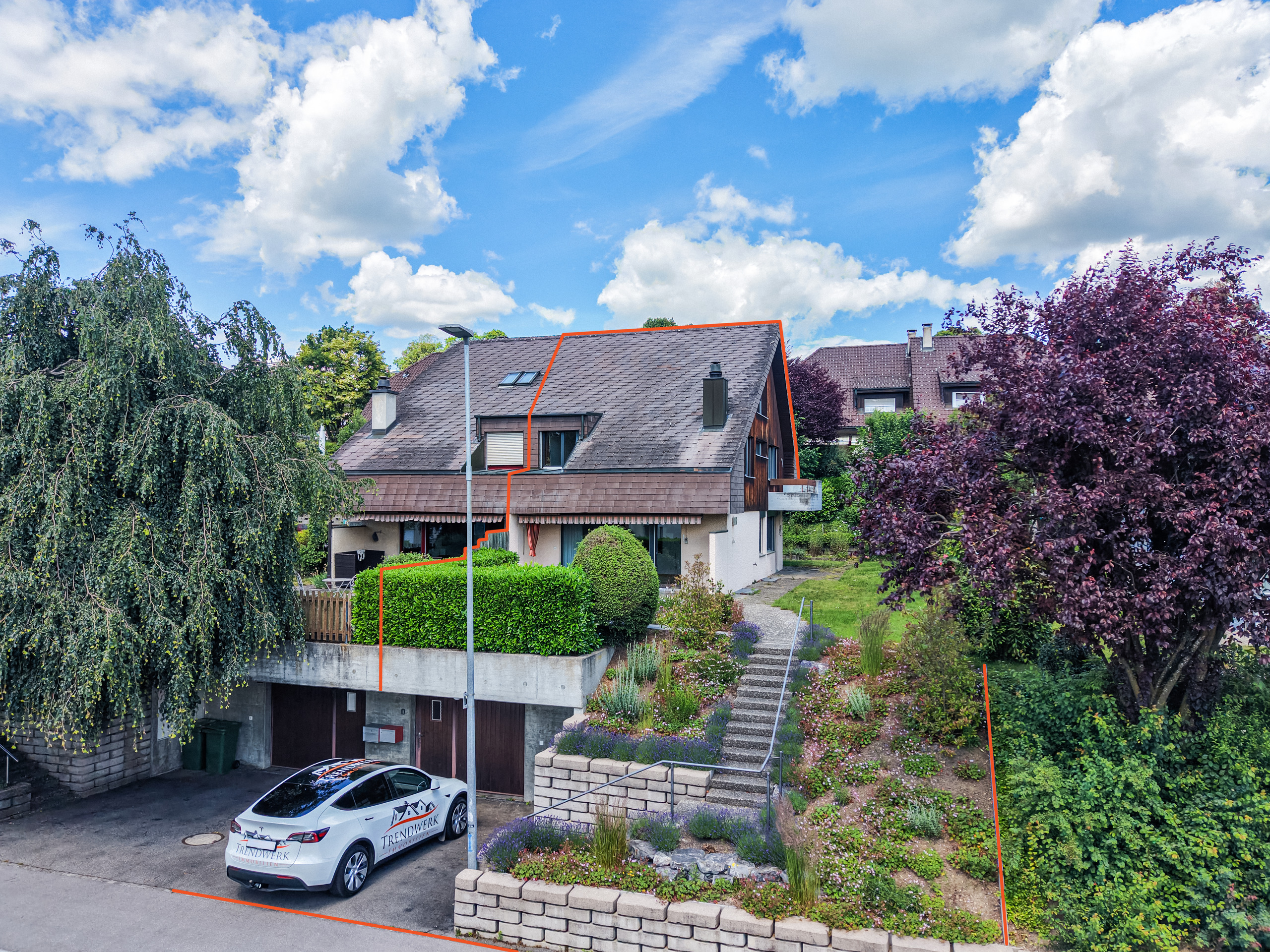 Wohnhaus mit steilem Satteldach und Garten