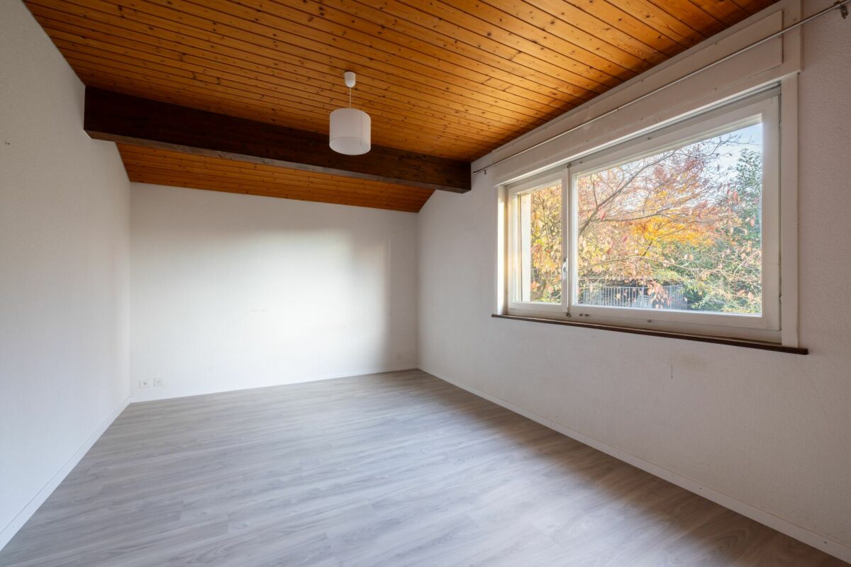 Leerer Raum mit Holzdecke und großem Fenster