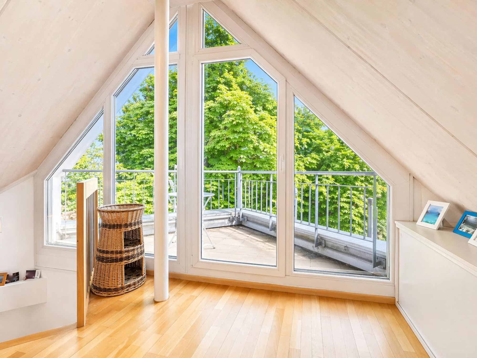 Heller Dachraum mit Panoramafenster und Balkonblick