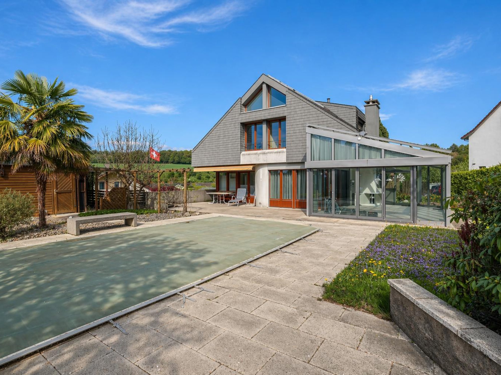 Moderner Wohnhausaußenbereich mit Terrasse und Wintergarten