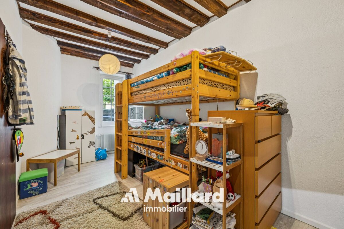 Kinderzimmer mit Hochbett und sichtbaren Holzbalken