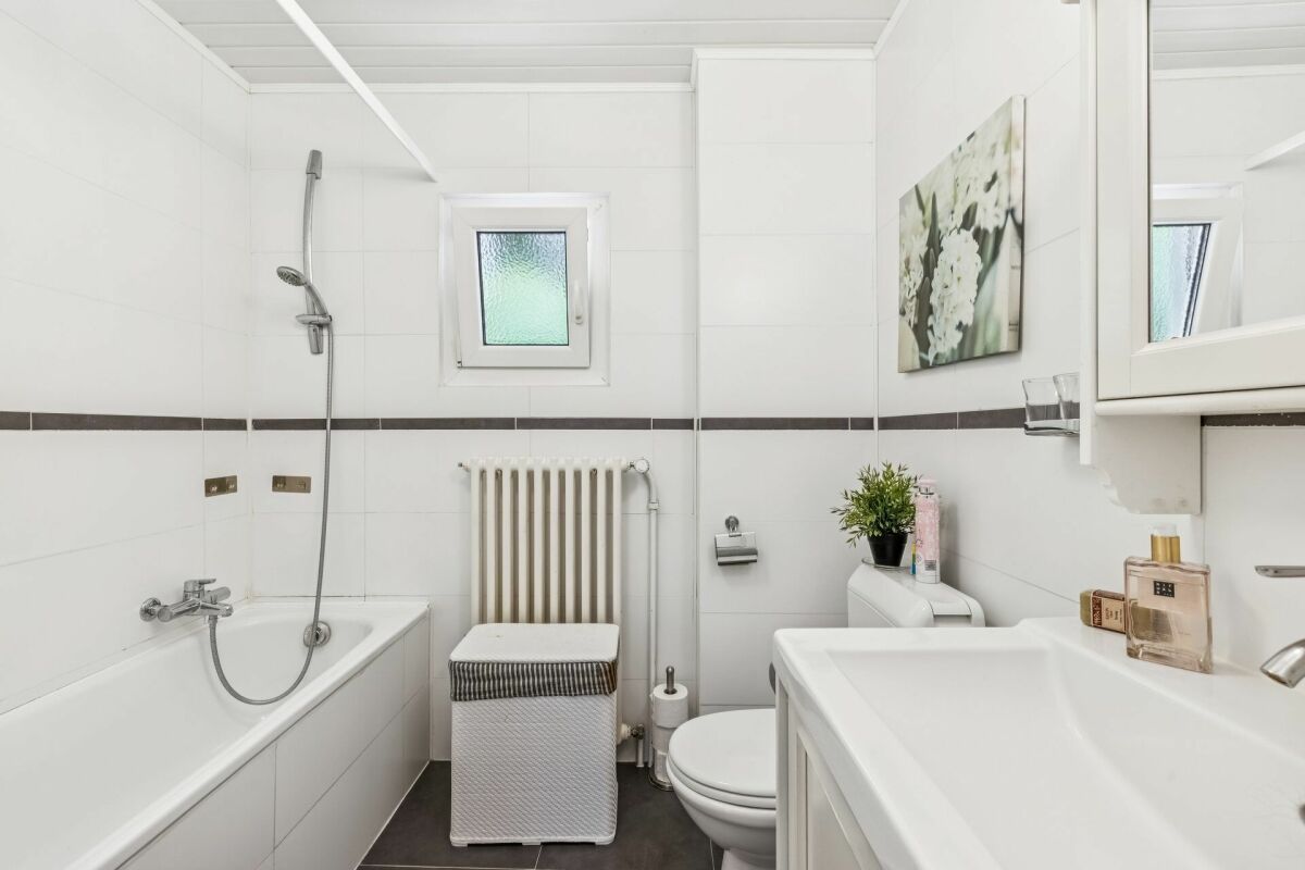 Helles, kleines Badezimmer mit Badewanne und WC