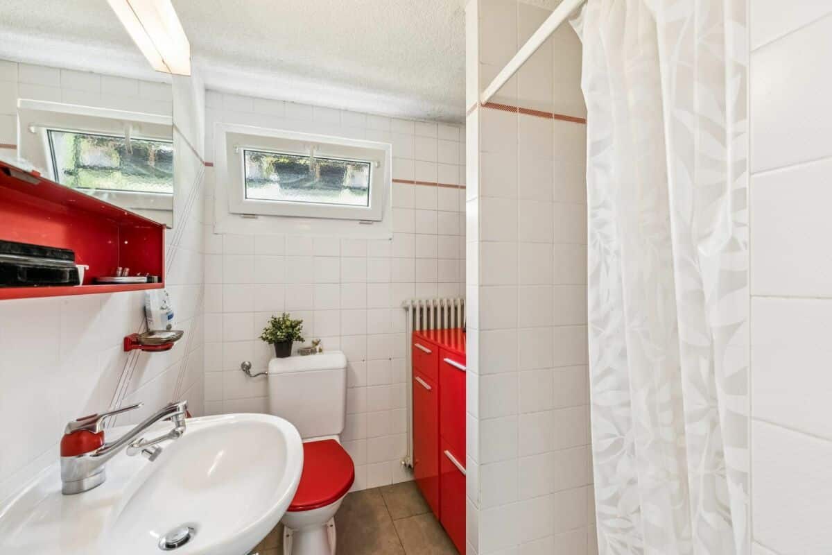 Kleines Badezimmer mit roten Akzenten