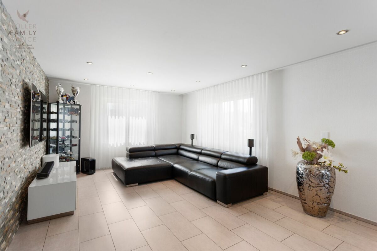 Modernes Wohnzimmer mit Ecksofa und Mosaikwand