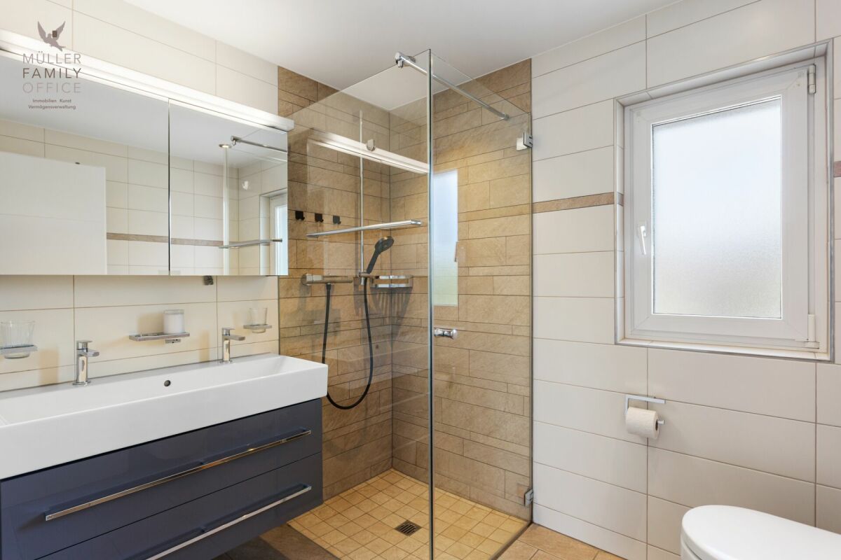 Modernes Badezimmer mit Glasdusche und Spiegelschrank