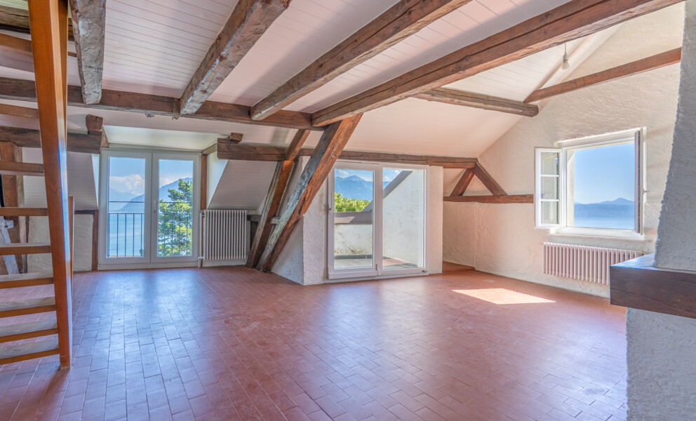 Dachgeschossraum mit Blick auf Wasser und Berge