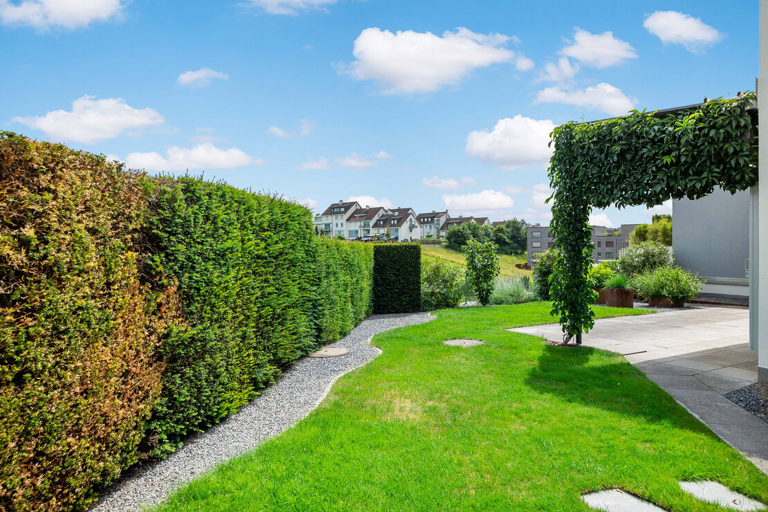 Gepflegter Garten mit Pergola und Blick ins Umfeld