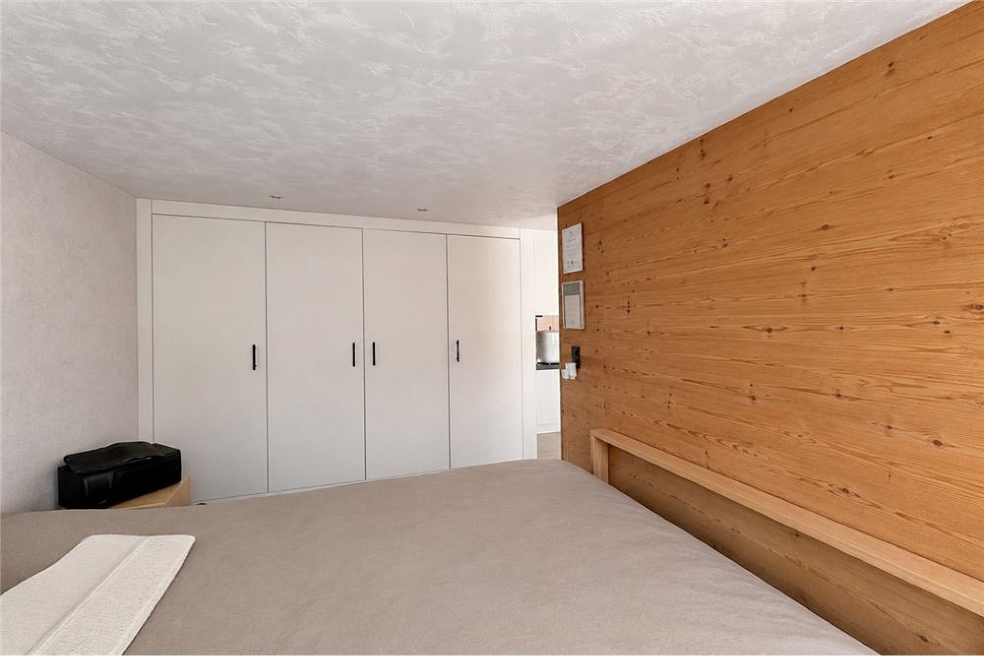 Modernes Schlafzimmer mit Einbauschrank und Holz-Akzentwand