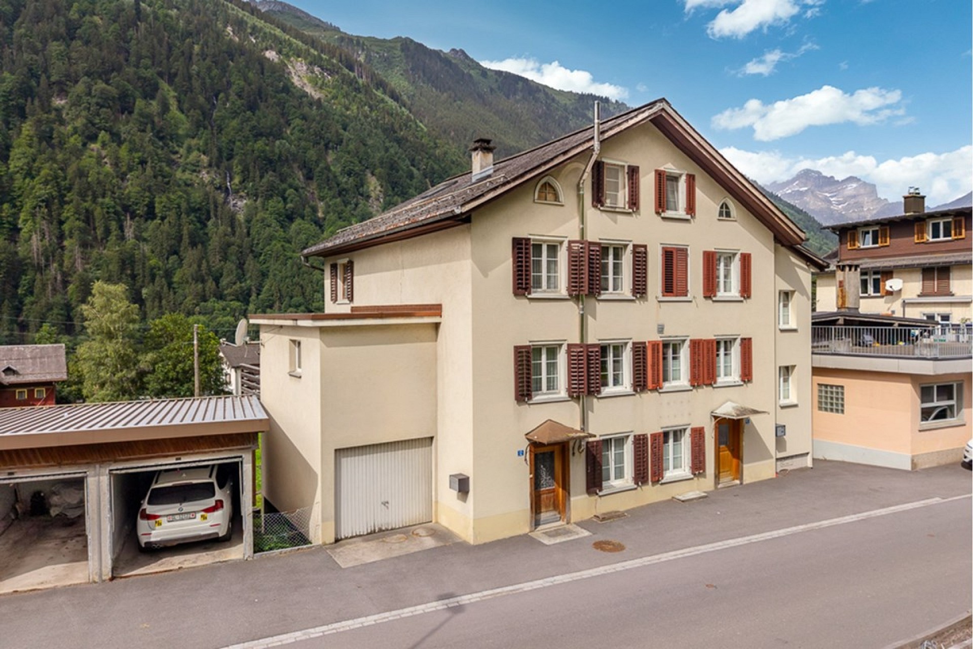Berghaus mit Garagen und alpiner Aussicht