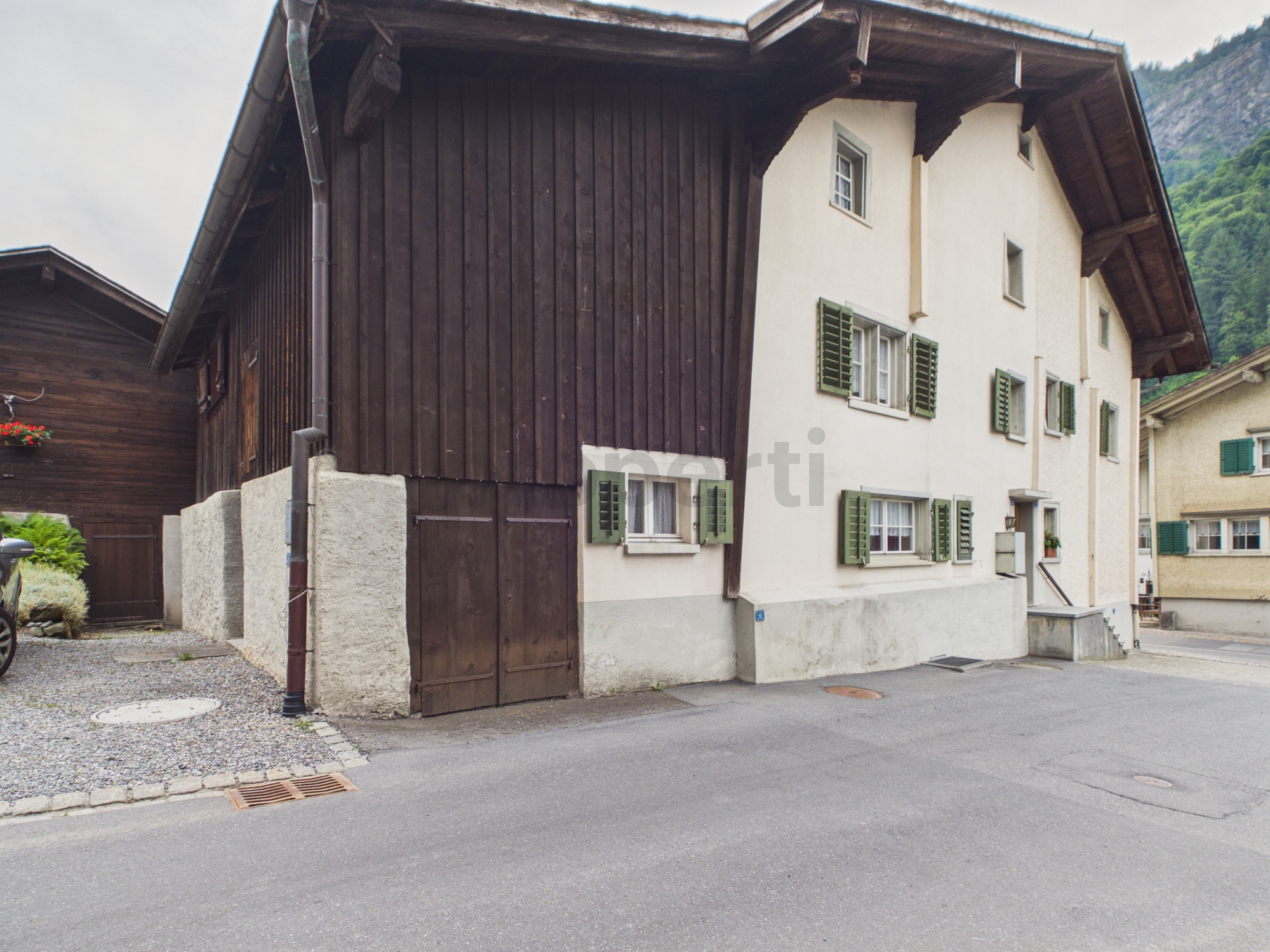 Alpines Wohnhaus mit Holzfassade und grünen Fensterläden