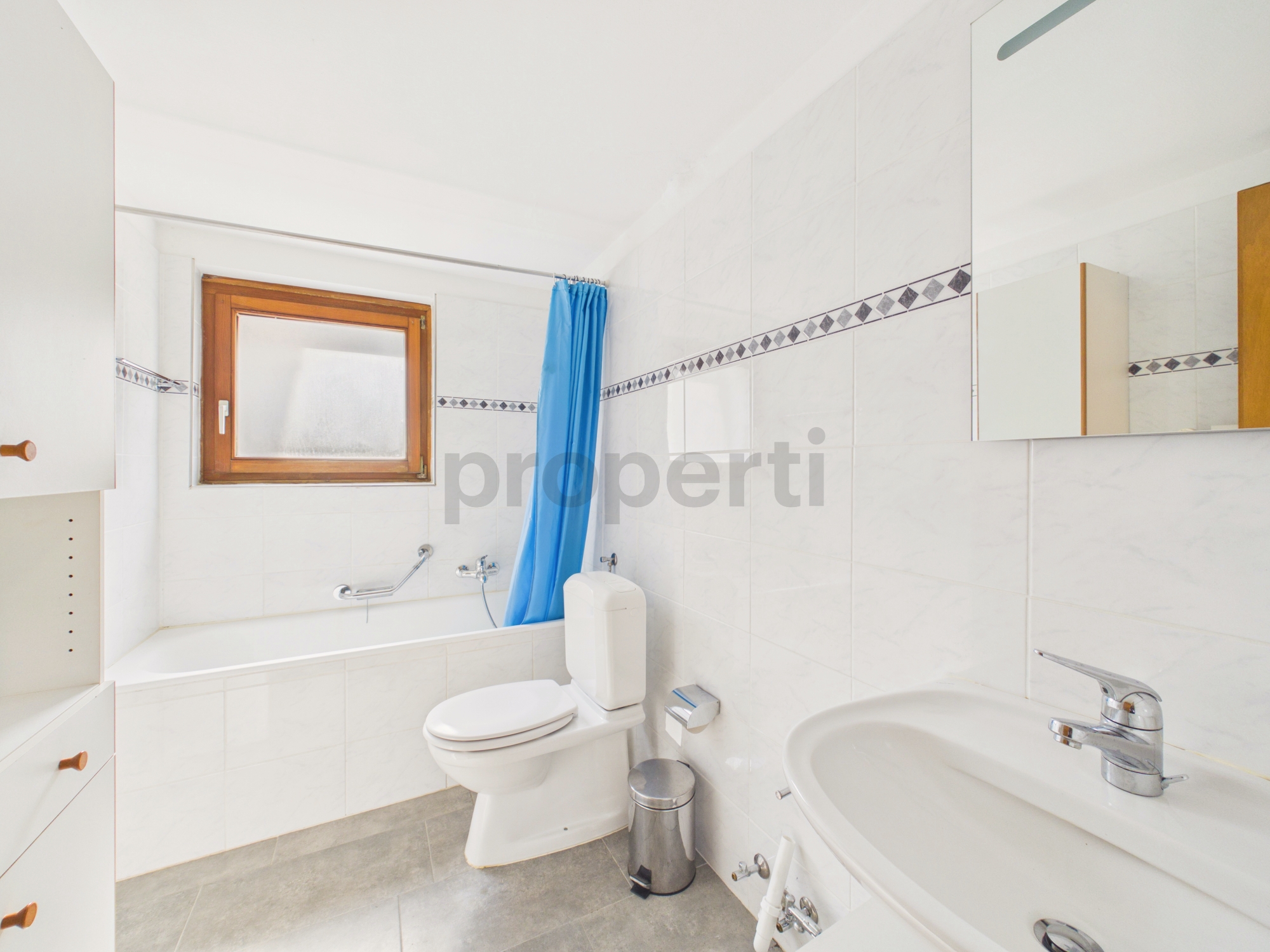 Helles Badezimmer mit Wanne, WC und Fenster