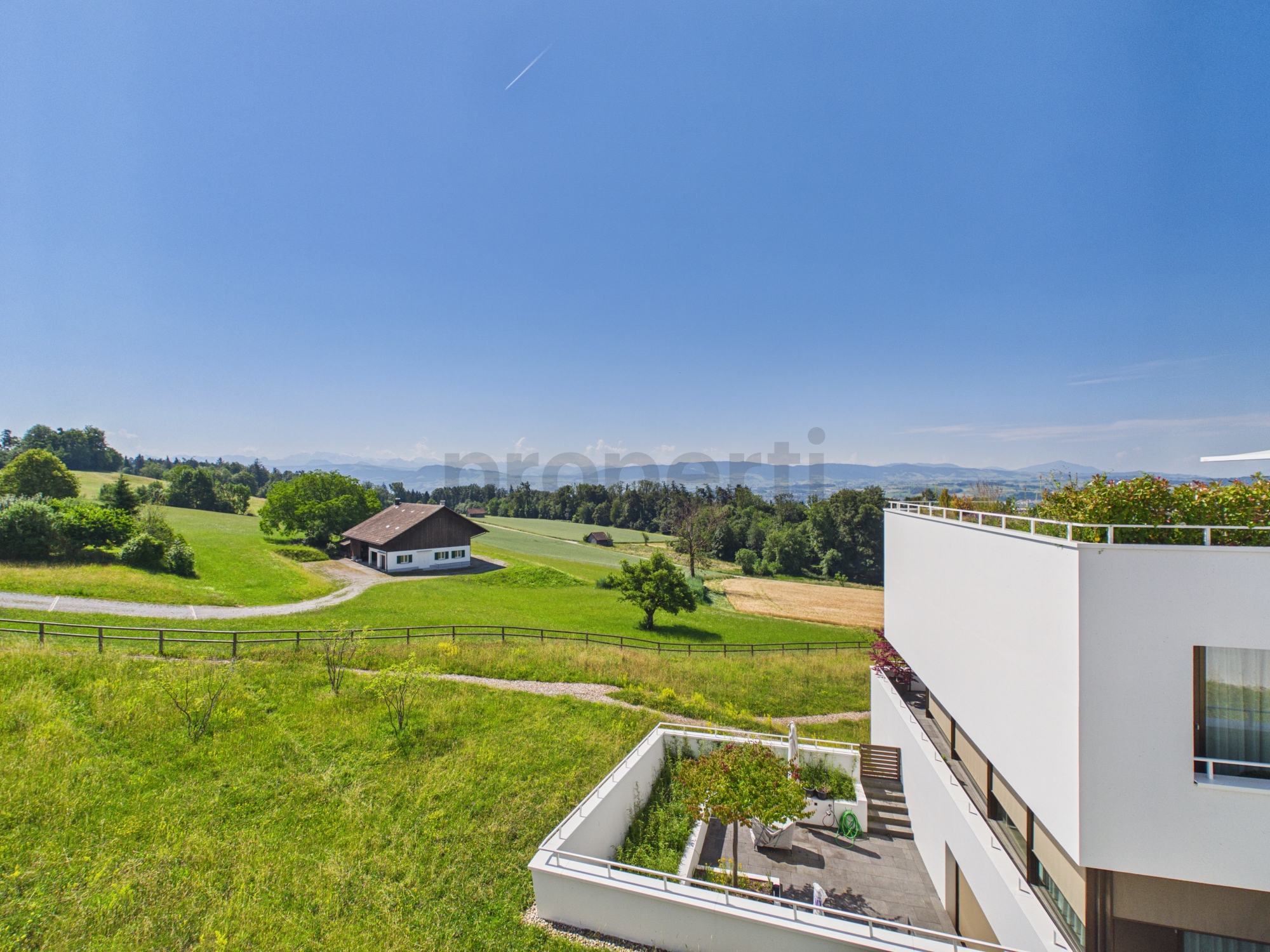 Ländliche Außenansicht mit modernem Wohnhaus und Weitblick