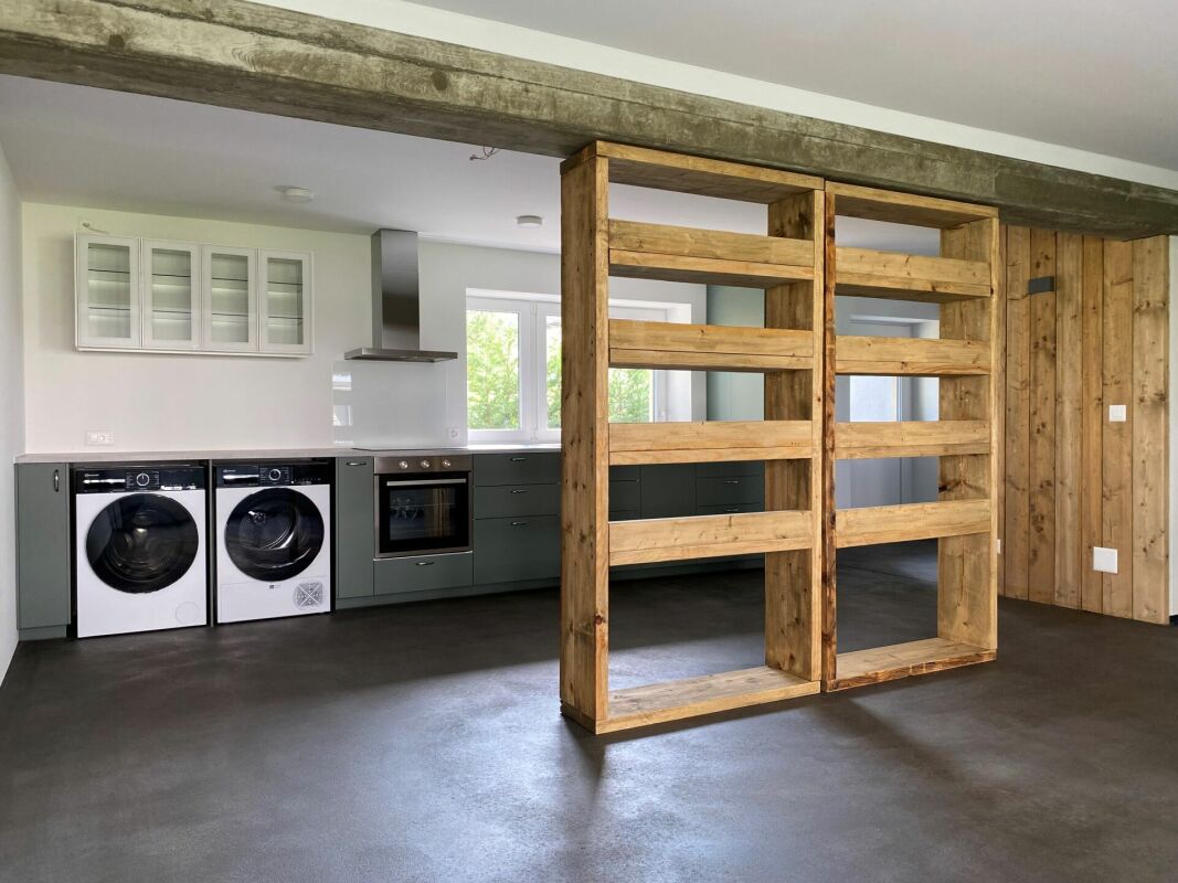 Offener Wohnbereich mit Küche und Holztrennwand