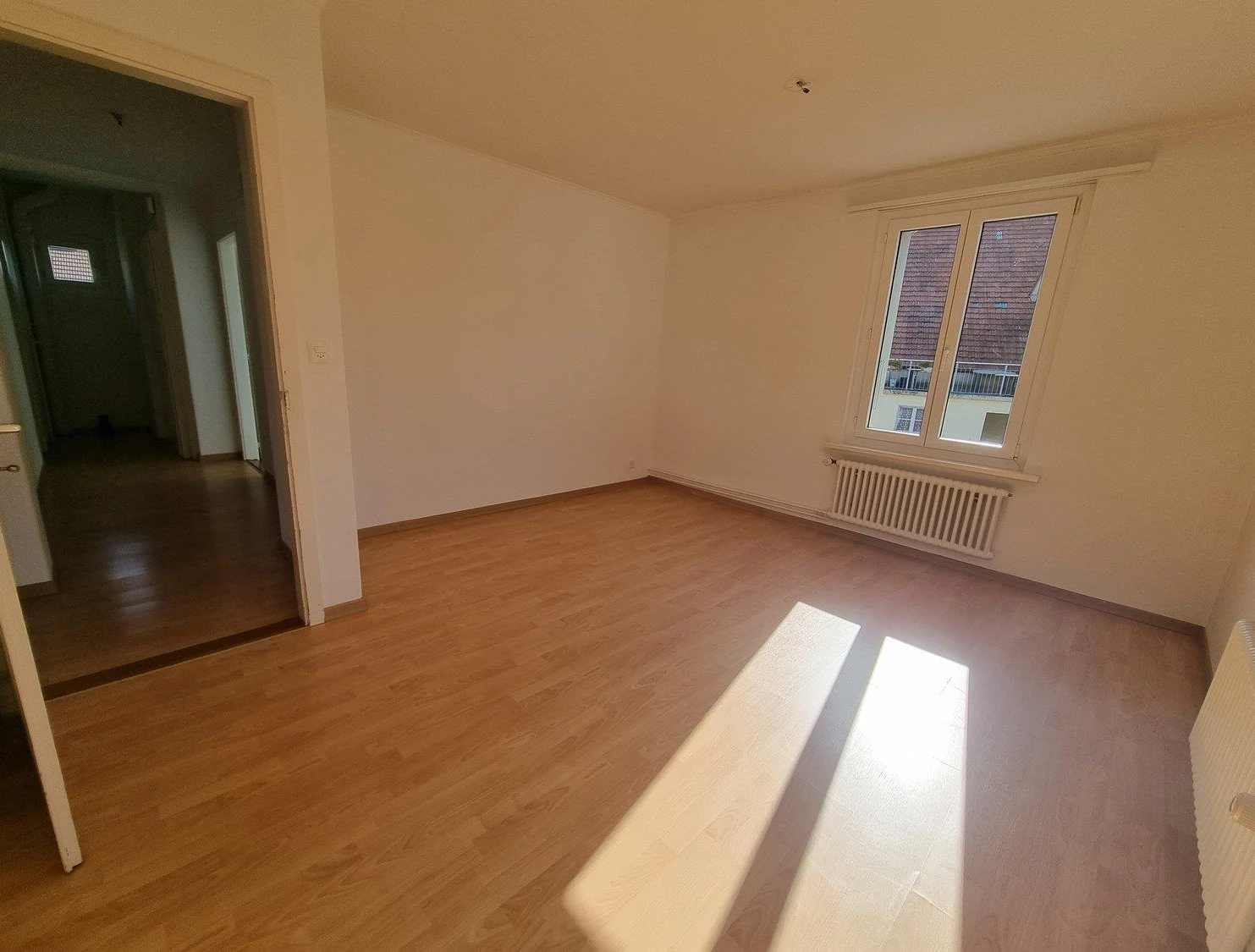 Leeres Zimmer mit Laminatboden und Fenster