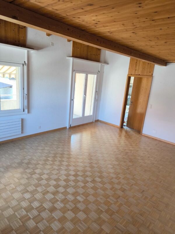 Leerer Wohnraum mit Holzbalkendecke