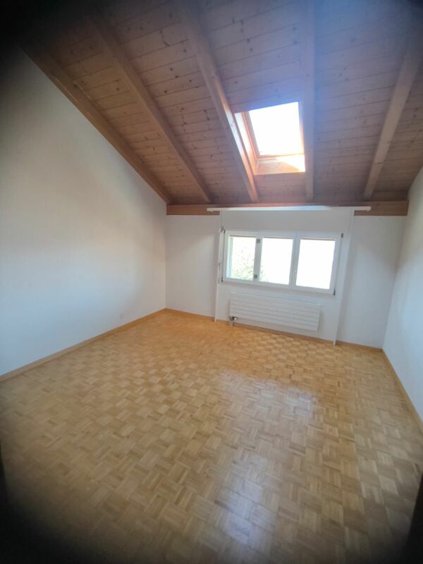 Dachgeschosszimmer mit Holzdecke und Dachfenster
