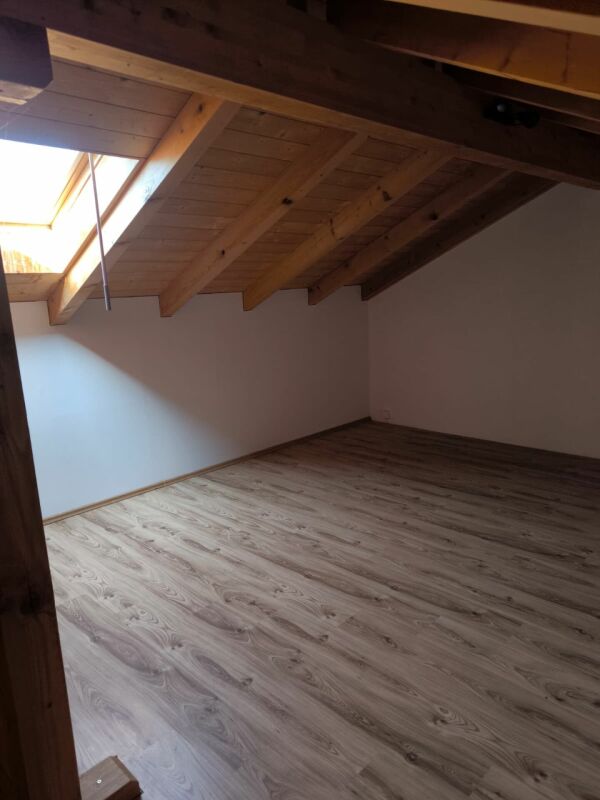 Dachgeschossraum mit sichtbaren Holzbalken