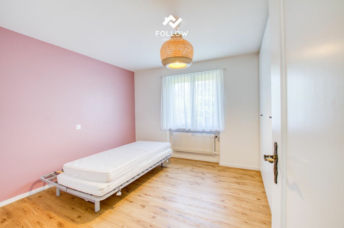 Helles Schlafzimmer mit Einzelbett und Fenster