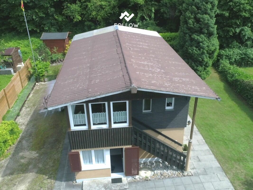 Außenansicht eines Hauses mit großem Walmdach und Balkon