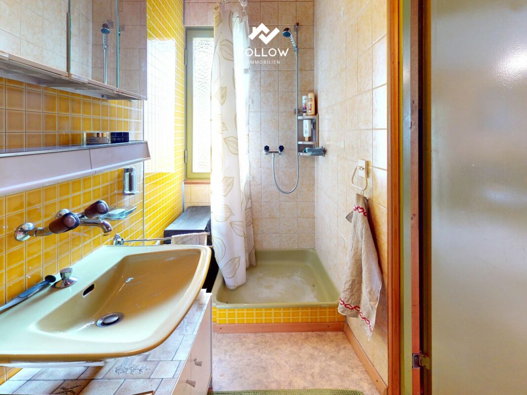 Badezimmer mit Dusche und Waschbecken