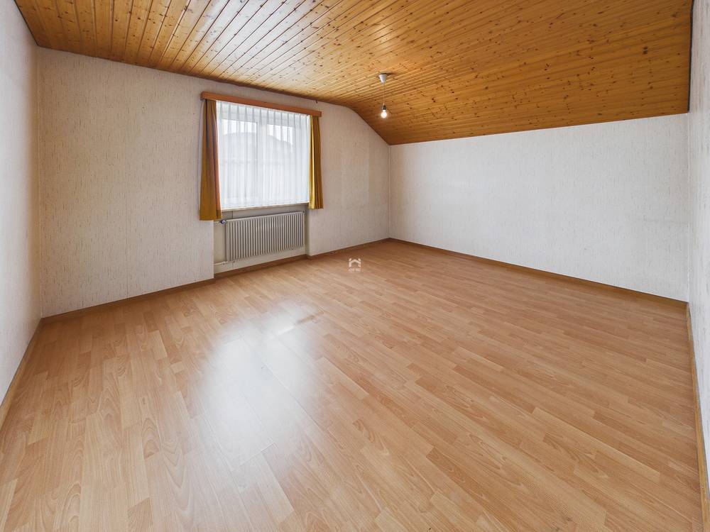 Leerer Raum mit Holzdecke und Laminatboden