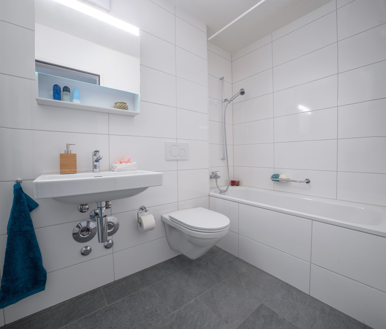 Modernes Badezimmer mit Badewanne, Wand-WC und Waschtisch